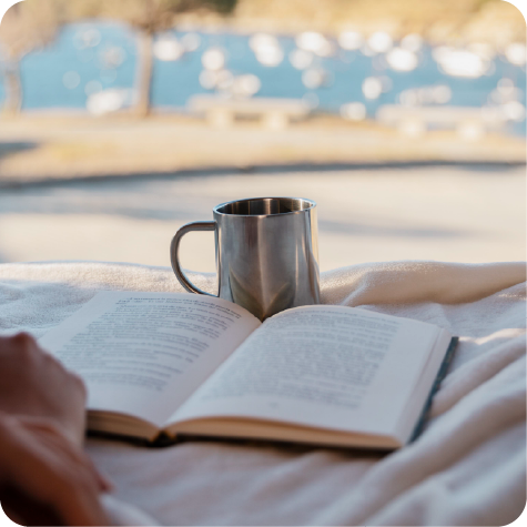 An open book, a candle and a warm mug on a soft surface